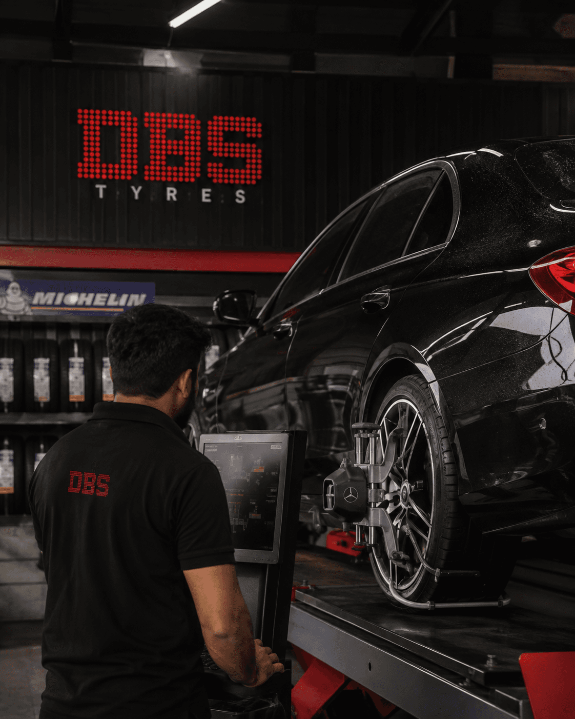 Technician performing 3D laser wheel alignment